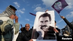 FILE - A demonstrator holds a picture of jailed Kurdish militant leader Abdullah Ocalan during a rally in Diyarbakir, Turkey, Feb. 27, 2025. The Peoples' Equality and Democracy Party has announced a new roadmap to peace following Ocalan's call for his group to disarm.