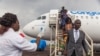 A health official uses a thermometer to measure the temperature of disembarking passengers at the airport at Mbandaka, Democratic Republic of the Congo, May 19, 2018.