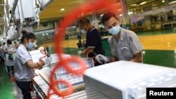 中国湖北武汉格力厂的工人在制作空调机的生产线上。（2021年8月9日）