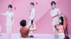 FILE - People take photos in front of a billboard with images of Anson Lo, a member of Cantopop boyband Mirror, in Hong Kong, Aug. 6, 2021.