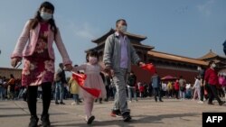 十一”长假期间游客们佩戴口罩游览故宫。