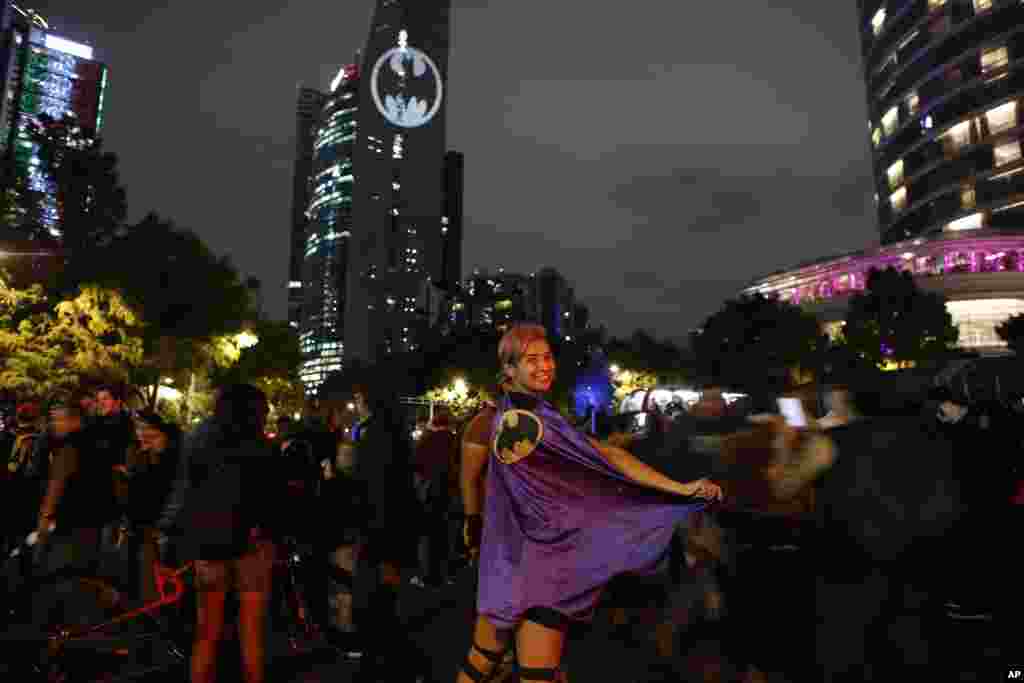 Stephanie Salgado poses with her cape during the lighting of a Bat-signal commemorating Batman's 80th anniversary in Mexico City, Sept. 21, 2019.