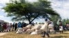 A man carries a full bag of donated maize grain, March 13, 2019, in the Mutoko rural area of Zimbabwe. Eastern Zimbabwe receives help to fight drought induced hunger, as a total of 32,000 villagers affected by drought in the Mutoko area. They received…