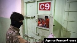 Pripadnik Sirijskih demokratskih snaga (SDF) stražari u zatvoru u kome se drže ljudi osumnjičeni da su bili pripadnici Islamske države, u gradu Hasakeh, 26. oktobra 2019.