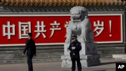 北京警察和便衣守在共产党万岁的巨幅标语墙前。(2013年11月7日) 