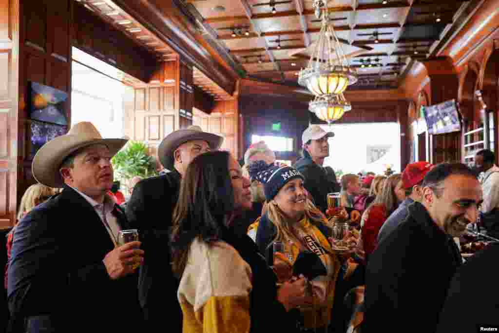 သမ္မတ ဒေါ်နယ်ထရမ့်ရဲ့ ကျမ်းသစ္စာကျိန်ဆိုပွဲကို ဝါရှင်တန်ဒီစီမြို့မှာ တီဗွီဖန်သားပြင်ပေါ် ကြည့်ရှုနေသူများ။
