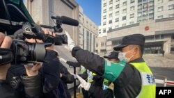 一名警察擋住記者的鏡頭阻止拍攝審訊公民記者張展的上海浦東新區法院外景。 （2021年12月28日）