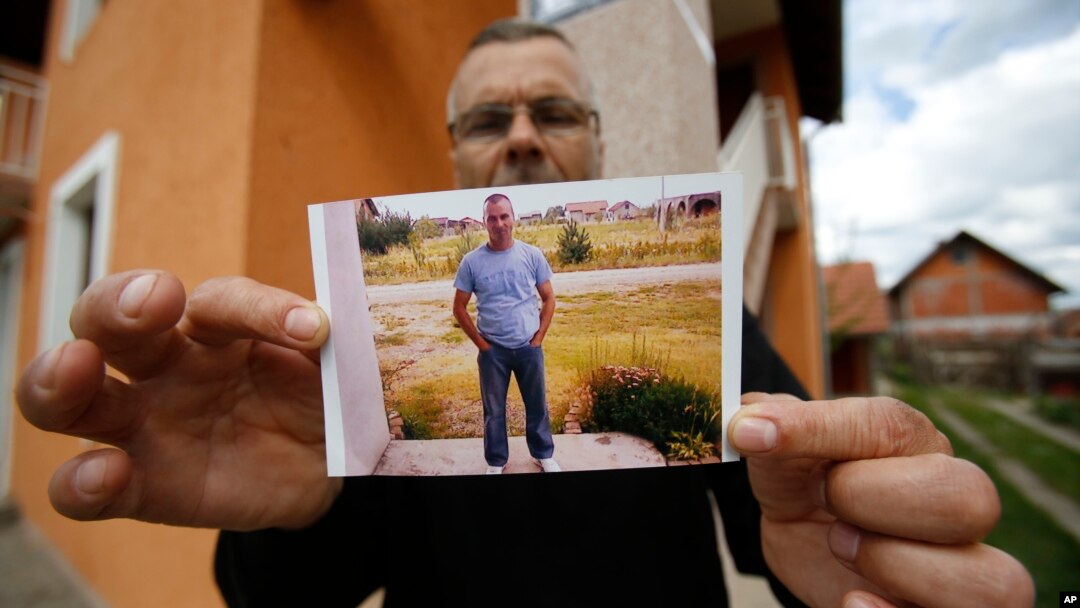 Bosnian Andjelko Djuric, 45, shows photos of his late brother Dragan Djuric, a police officer who was killed in Monday's attack at a police station in the eastern Bosnian town of Zvornik, 200 kilometers (124 miles) east of Sarajevo, April 28, 2015.