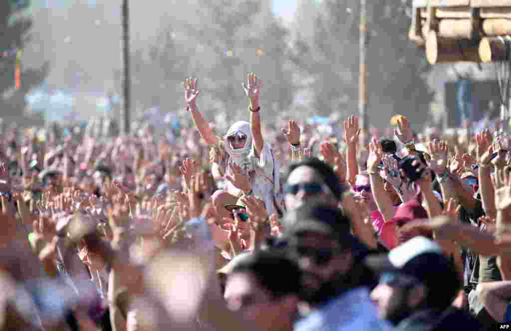 People watch the start of the solar eclipse and raise their hands in prayer in an eclipse viewing event led by Native American elders, at Big Summit Prairie ranch in Oregon&#39;s Ochoco National Forest near the city of Mitchell, Aug. 21, 2017.