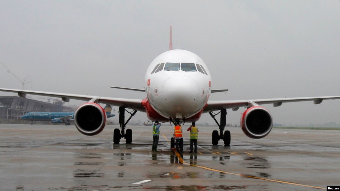 FILE - Ground staff check VietJet A320 airplane before departure for Bangkok, Noi Bai international airport, Hanoi, September 2013.