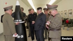 Na fotografiji načinjenoj od video snimka vidi se severnokorejski lider Kim Džong Un kako vrši inspekciju nuklearne bojeve glave, na nedefinisanoj lokaciji i u neodređeno vreme (Foto: KRT/via Rojters)