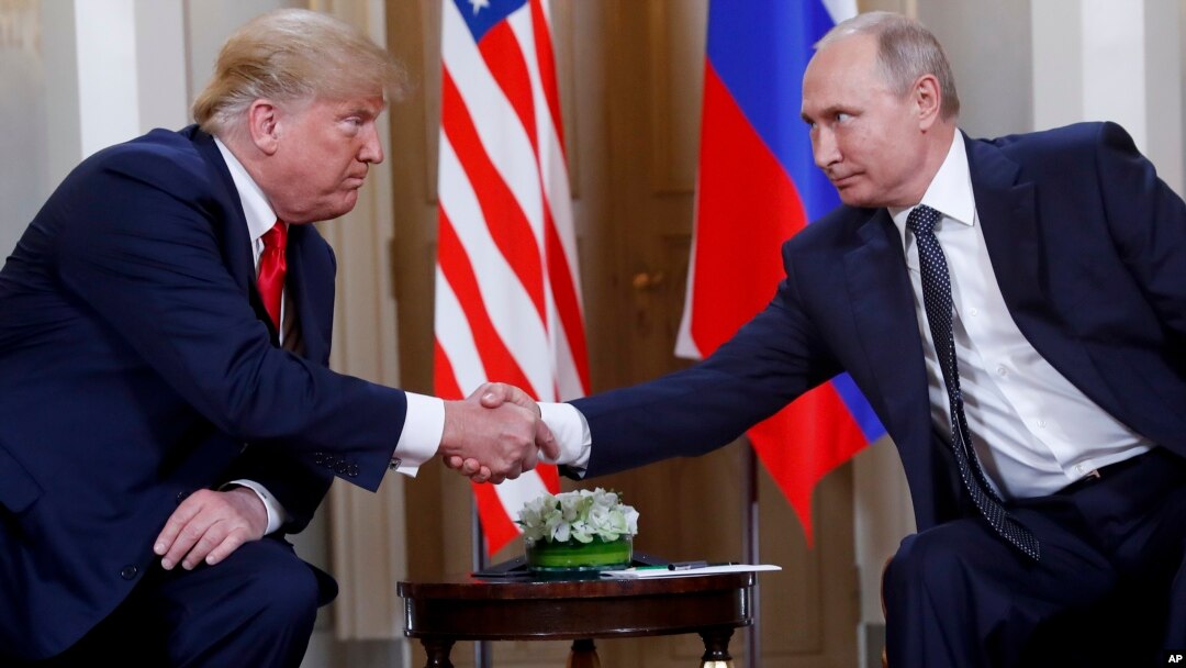 U.S. President Donald Trump, left, and Russian President Vladimir Putin, right, shake hand at the beginning of a meeting at the Presidential Palace in Helsinki, Finland, July 16, 2018. 