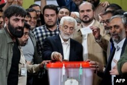 Capres Iran dan mantan negosiator Saeed Jalili (tengah) memasukkan surat suara di sebuah TPS di Teheran Iran, Jumat, 5 Juli 2024. (Foto: Rahed Homavandi/AFP)