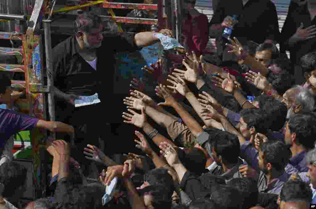 Shi'ite Muslims jostle to get free food donated by businessmen during a procession to mark Ashoura in Rawalpindi, Pakistan.