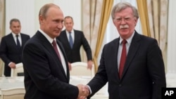 Ruski predsednik Vladimir Putin rukuje se sa američkim savetnikom za nacionalnu bezbednost, Džonom Boltonom, tokom susreta u Moskvi, 27. juna 2018. 