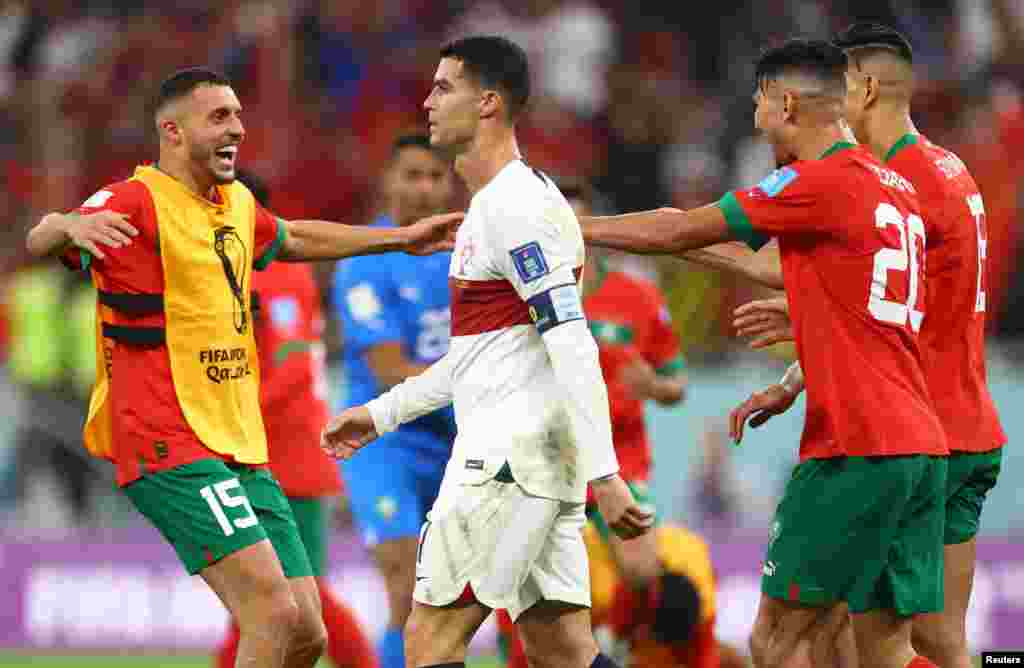 Jogadores de Marrocos festejam a passagem às meias-de-final, enquanto o jogador de Portugal, Cristiano Ronaldo, abandona o campo após a derrota por 1-0.&nbsp;Al Thumama Stadium, Doha, Qatar Dez 10, 2022