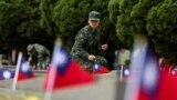 一名台灣軍人在金門古寧頭戰役75週年紀念儀式上為公共墓地的一座墳墓上香。 (2024年10月25日)