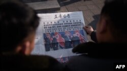 지난 2월 북한 평양 주민들이 로동신문 1면에 실린 하노이 2차 미-북 정상회담 기사를 읽고 있다.