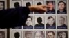 In this Thursday, Dec. 6, 2018 file photo, a sexual abuse victim points to the photos of Catholic priests accused of sexual misconduct by victims during a news conference in Orange, Calif. 