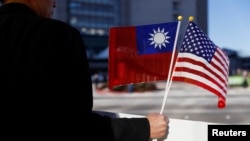 A demonstrator holds flags of Taiwan and the United States in support of Taiwanese President Tsai Ing-wen in Burlingame, California, Jan. 14, 2017. 