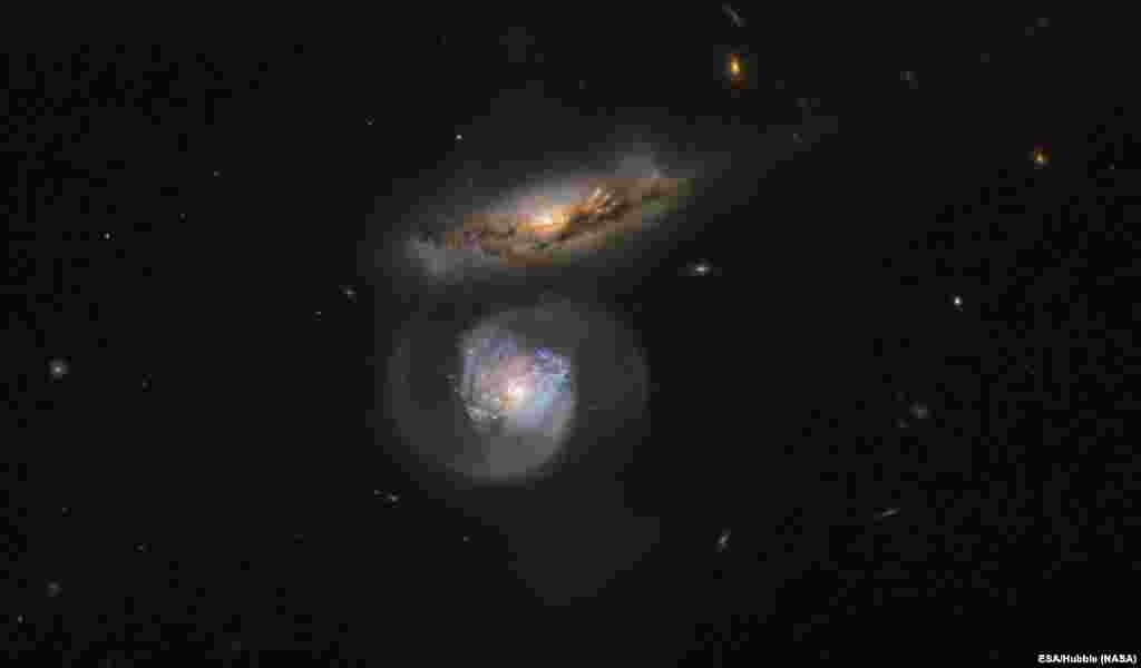 The galaxy named MCG+01-38-005 (the lower, blue-tinted one) is a special kind of megamaser and its active galactic nucleus pumps out huge amounts of energy, which stimulates clouds of surrounding water.