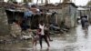 Wani mutum dauke da yaransa bayan da guguwar Idai ta ratsa ta yankin Beira a aksar Mozambique, Maris 23, 2019. 