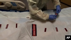 Registered nurse Bryan Hofilena attaches "COVID Patient" stickers on a body bag of a patient who died of coronavirus at Providence Holy Cross Medical Center in Los Angeles, Dec. 14, 2021.