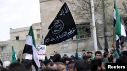 Para pengunjuk rasa membawa bendera Al-Qaeda dalam demonstrasi anti-pemerintah setelah salat Jumat di Kota Marat Numan di Provinsi Idlib, Suriah, pada 11 Maret 2016.