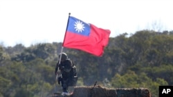 一名台灣士兵手舉台灣旗幟參加新竹舉行的軍演，模擬反擊中國軍隊攻台。（2021年1月19日）