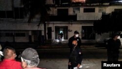 FILE- Police guard the perimeter of a scene where Heber Lopez, a journalist who ran NoticiasWeb, was shot and killed, in Salina Cruz, in Oaxaca state, Mexico Feb. 10, 2022.