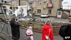 Ljudi se okupljaju oko ostataka granate, u Kijevu, 24. februara 2022.