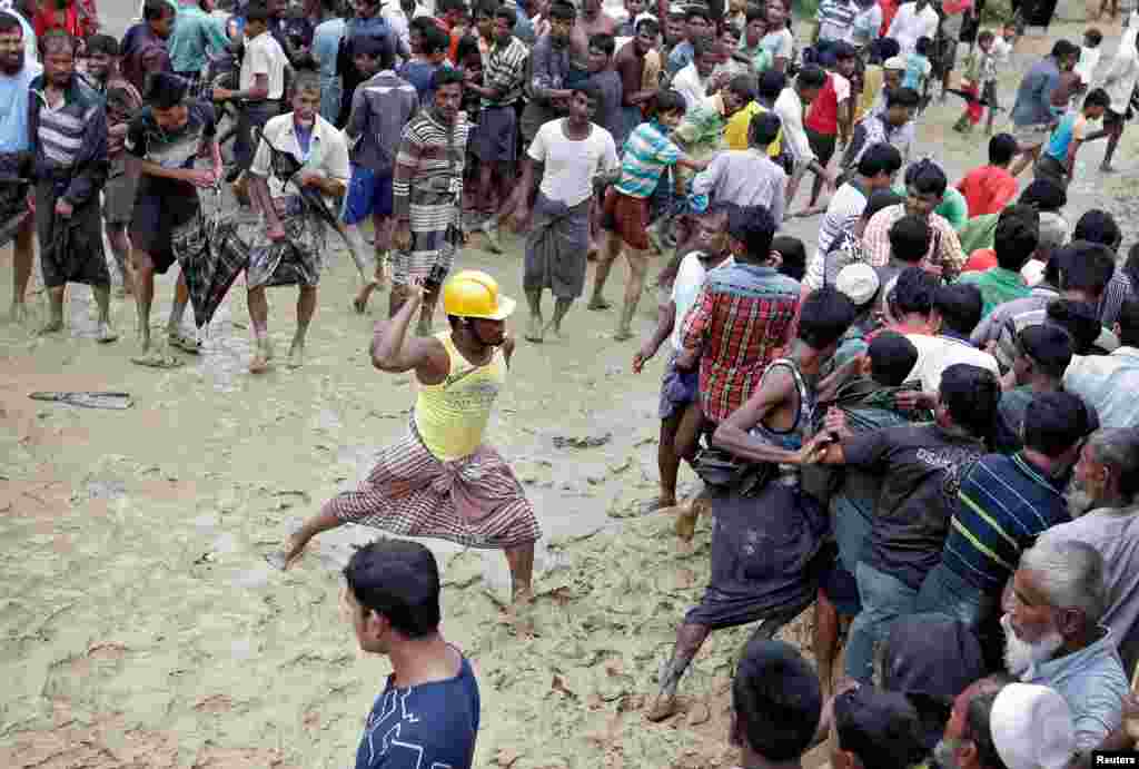 Rohingya refugees react as aid is distributed in a camp in Cox's Bazar, Bangladesh.