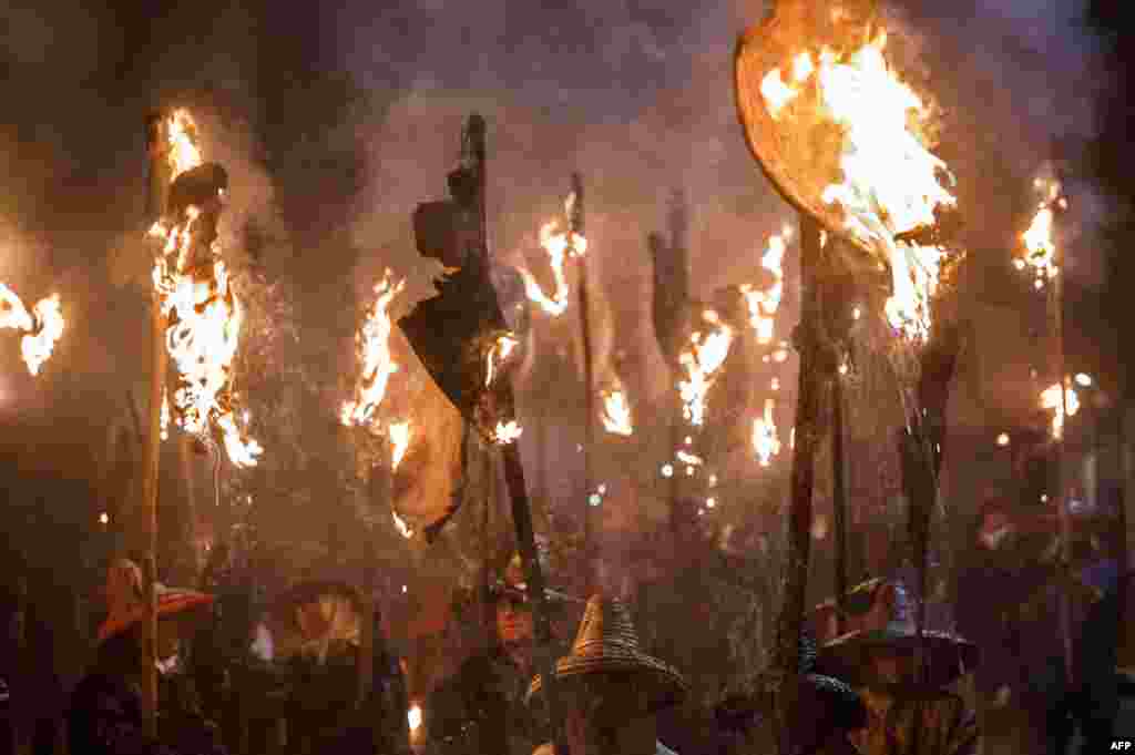'Mayorganos' (Mayorga locals) carry flaming wineskin torches during the 'Vitor's Civic Procession' in Mayorga, near Valladolid, Spain, Sept. 27, 2017.