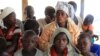 Mothers and children, refugees from from Democratic Republic of Congo, wait to be registered by UNHCR personnel, in Ntoroko, Uganda, Feb. 17, 2018.