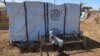 FILE - A boy displaced from Al Jazirah state due to Rapid Support Forces (RSF) violence, lies down on a bench with the logo of the International Organization for Migration behind him in New Halfa, Sudan, Nov. 2, 2024.