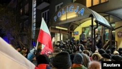 Demonstranti se okupili u znak podrške bivšem ministru unutrašnjih poslova Kaminskom i njegovom zameniku Vasiku iz partije PiS ispred policijske stanice gde su obojica političara uhapšeni u Varšavi. 9. januar, 2024. (Foto: REUTERS/Karol Badohal)