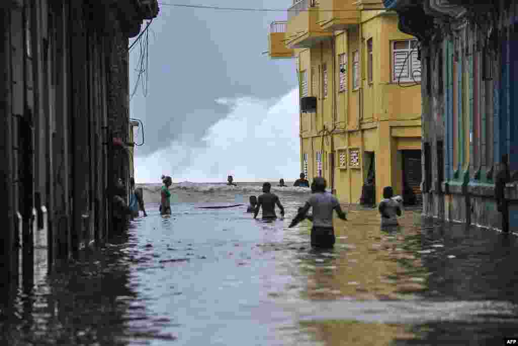 Cubans wade through a flooded street near the Malecon in Havana. Deadly Hurricane Irma battered central Cuba, knocking down power lines, uprooting trees and ripping the roofs off homes as it headed towards Florida.