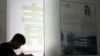 In this June 26, 2014 photo, 16-year-old Zhang Kaisheng studies near advertisements for oversea schools at Focus Education, a tutoring and consulting agency in Beijing.