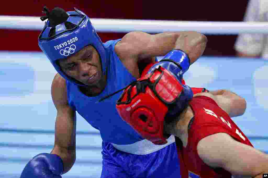 Uzbekistan's Raykhona Kodirova, right, exchanges punches with Naomie Yumba, of the Democratic Republic of the Congo, during their women's lightweight 60-kg boxing match at the 2020 Summer Olympics, Friday, July 30, 2021, in Tokyo, Japan. (AP Photo/Frank Franklin II)