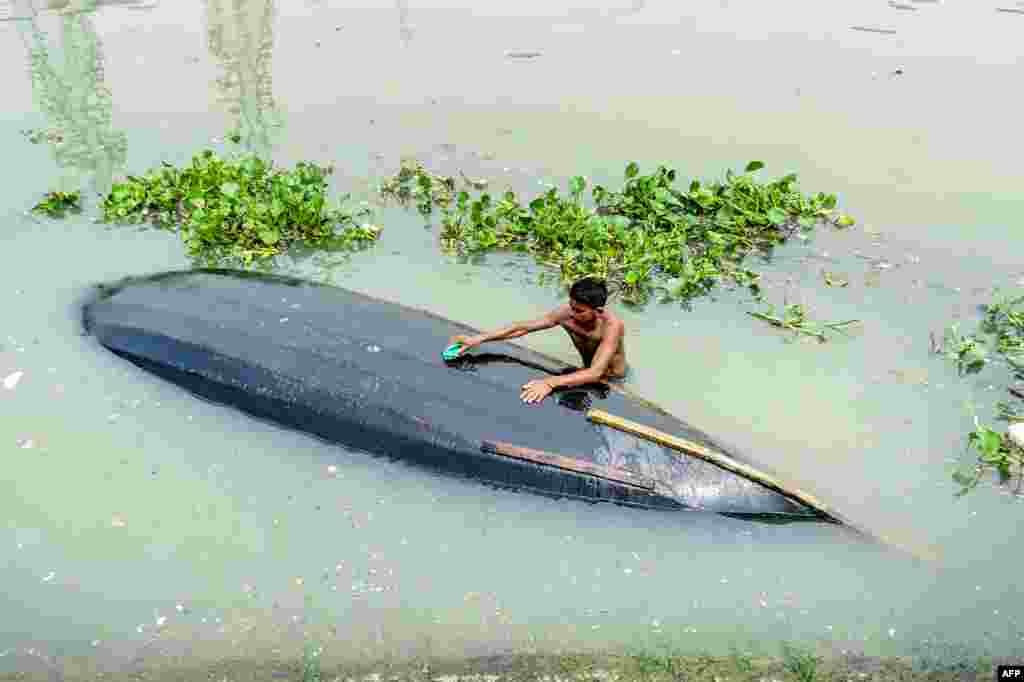 A man cleans his boat in Buriganga River in Dhaka, Bangladesh.