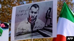 FILE - People hold placards bearing portraits of Iranian rapper Toomaj Salehi, who is arrested in Iran during a rally in support of Iranian women in Istanbul, on November 26, 2024.