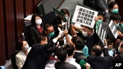 香港立法會泛民主派議員在內務委員會的一個會議期間舉牌抗議中國人大製定香港國安法，他們被保安阻攔。（2020年5月22日）
