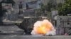 Sebuah bom yang dilemparkan oleh warga Palestina meledak di samping kendaraan tentara Israel selama serangan militer di kamp pengungsi Jenin, kubu militan, di Tepi Barati, Selasa, 4 Juli 2023. (AP/Majdi Mohammed)