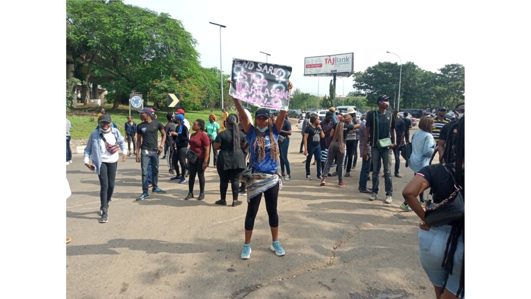 A female protester holds up a placard reading 'End SARS' during continued protests at the popular Berger junction in Abuja, Oct. 14, 2020. (Timothy Obiezu/VOA)