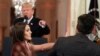 As President Donald Trump points to CNN's Jim Acosta, a White House aide takes the microphone from the reporter during a news conference in the East Room of the White House, Nov. 7, 2018, in Washington.