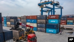 FILE - Sebuah truk memindahkan kontainer di Stasiun Tuanjiecun di Taman Pusat Logistik Internasional Chongqing di Kotamadya Chongqing, China barat daya, 5 Mei 2024. (Huang Wei/Xinhua via AP, File)