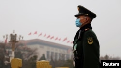 Paravojni policajac stražari nedaleko od Velikike narodne dvorane pred otvaranje Nacionalnog narodnog kontresa u Pekingu, Kina, 5. marta 2021. U izveštaju američkih obaveštanih agencija, Kina predstavlja pretnju po SAD.