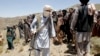 FILE - Members of a Taliban breakaway faction walk during a gathering, in Shindand district of Herat province, Afghanistan, May 27, 2016.
