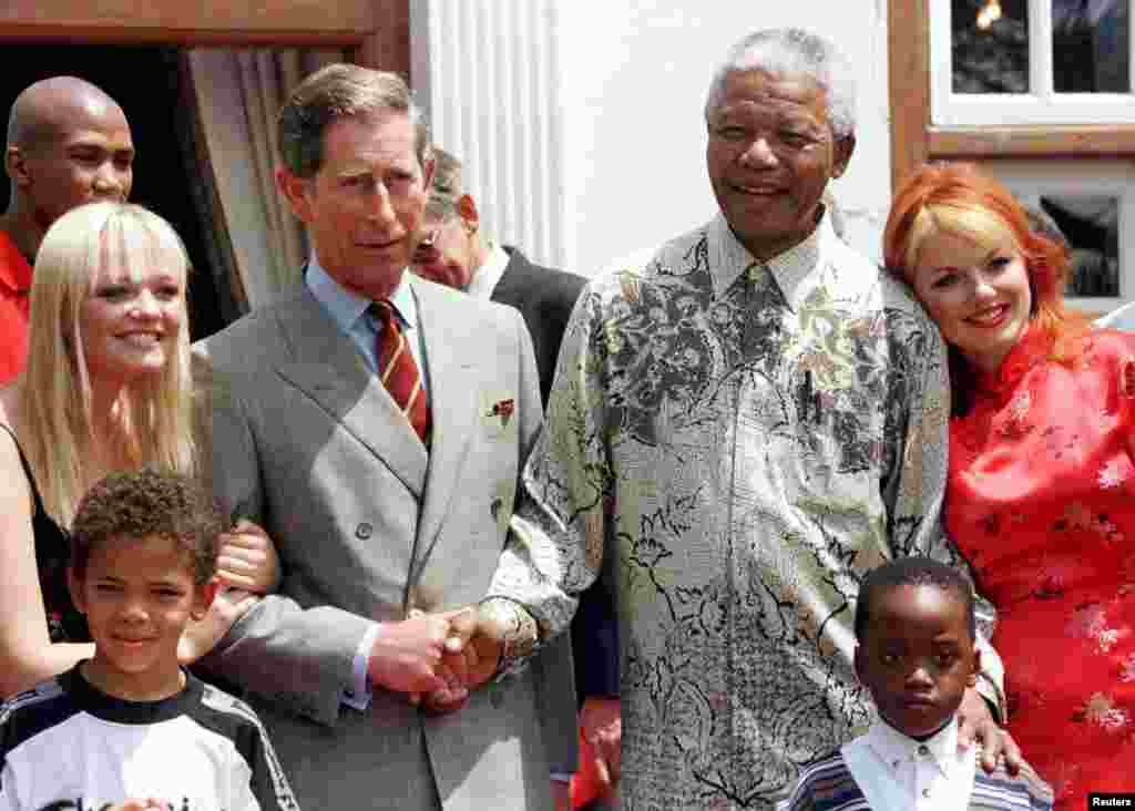 Aperto de mão entre o Presidente Nelson Mandela e o Príncipe Charles do Reino Unido ao lado de duas das cantoras do grupo Spice Girls Emma (E), e Gerri (D) na residência de Mandela. Nov. 1, 1997.