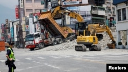 2024年4月4日，工作人員正在台灣花蓮市一個街區應對大地震產生的房屋傾塌。